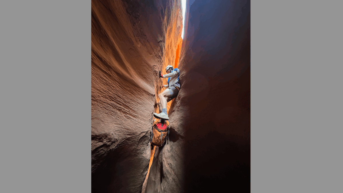 Root Roepke Canyoneering in Canyonlands National Park when the slot is too small to wear your backpack.